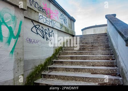 Marches en béton menant au pont de lecture. Le mur est recouvert de graffiti. Banque D'Images