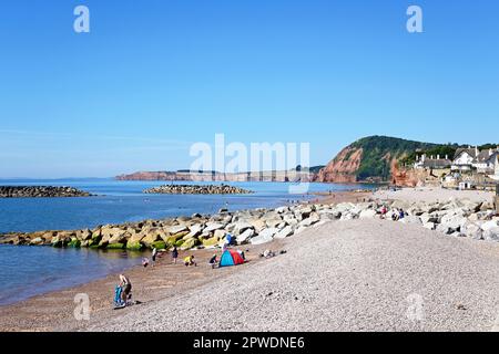 Touristes se détendant sur la plage avec vue sur les falaises, Sidmouth, Devon, Royaume-Uni, Europe. Banque D'Images