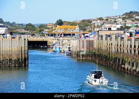 Bateau entrant dans le port avec la porte de la Sluice et les bâtiments de la ville à l'arrière, West Bay, Dorset, Royaume-Uni, Europe. Banque D'Images