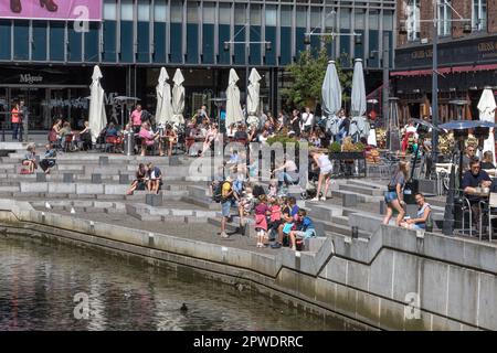 Les gens assis dans Vadestedet populaire dans les bars, cafés et restaurants sur les terrasses de la rivière Aarhus au bord de la rivière dans le centre-ville par Aboulevarden. Aarhus Danemark. Banque D'Images