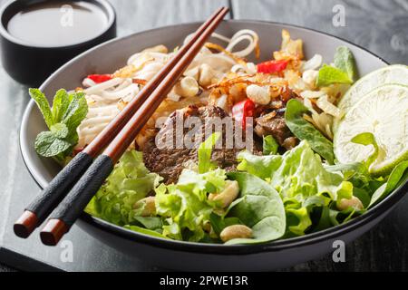 Bol de salade de nouilles de bœuf mélangées Pho Tron sur la table en bois. Horizontale Banque D'Images