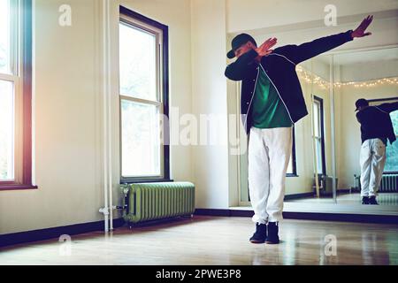 La dab est au service de cette multitude. un jeune homme dabbing pendant une routine de danse en studio. Banque D'Images