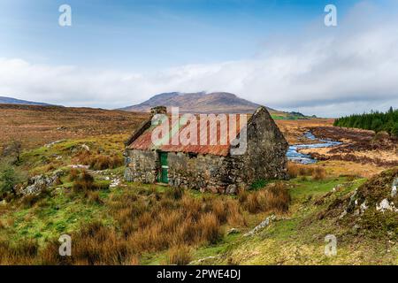 Un ancien cottage avec un toit rouillé à Maam Cross dans le parc national du Connemara à Galway, sur la côte ouest de l'Irlande Banque D'Images