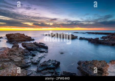 Un lever de soleil époustouflant sur la plage rocheuse de Torre de la Sal, sur la côte méditerranéenne de l'Espagne Banque D'Images