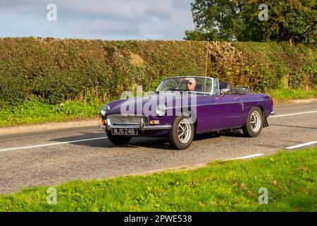 Années 1974 70 seventies MG B Purple car essence 1798 cc voiture de sport britannique ; voiture classique isolée voyageant sur une voie de campagne à Congleton, Royaume-Uni Banque D'Images