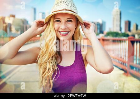 C'est un grand amoureux de la ville. une jeune femme souriante se promenant dans la ville en été. Banque D'Images