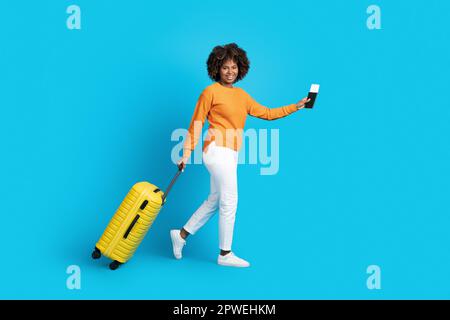 Bonne jeune femme noire voyageur marchant sur bleu, espace de copie Banque D'Images