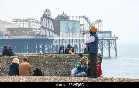 Brighton UK 30th avril 2023 - les visiteurs profitent du soleil chaud sur la plage et le front de mer de Brighton tandis que les foules affluent vers le bord de mer pour le week-end de vacances en banque : Credit Simon Dack / Alay Live News Banque D'Images