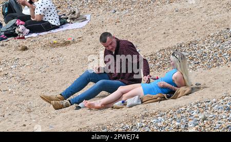 Brighton UK 30th avril 2023 - les visiteurs profitent du soleil chaud sur la plage et le front de mer de Brighton tandis que les foules affluent vers le bord de mer pour le week-end de vacances en banque : Credit Simon Dack / Alay Live News Banque D'Images