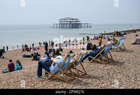 Brighton UK 30th avril 2023 - les visiteurs profitent du soleil chaud sur la plage et le front de mer de Brighton tandis que les foules affluent vers le bord de mer pour le week-end de vacances en banque : Credit Simon Dack / Alay Live News Banque D'Images