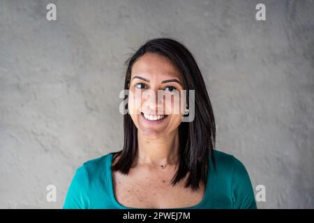 Portrait d'une femme nord-africaine heureuse - jeune femme marocaine confiante et souriante avec des cheveux lisses et des dents particulières s'amusant en posant en fron Banque D'Images