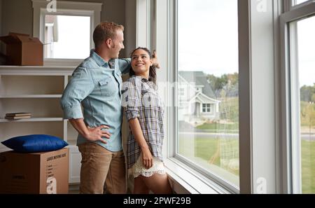 Passer ensemble à des choses plus grandes et meilleures. un couple qui se déplace dans leur nouvelle maison. Banque D'Images