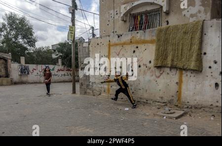 28 avril 2023, Gaza, la bande de Gaza, Palestine : les enfants palestiniens jouent au football devant leur domicile dans la ville de Beit Hanoun, dans le nord de la bande de Gaza. Leurs maisons ont été endommagées pendant la guerre de 2021 dans la bande de Gaza. (Credit image: © Mahmoud Issa/Quds Net News via ZUMA Press Wire) USAGE ÉDITORIAL SEULEMENT! Non destiné À un usage commercial ! Banque D'Images