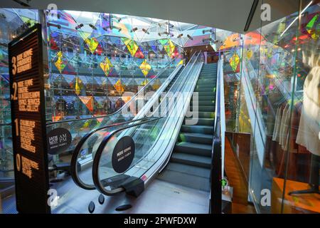 Paris, France - 9 avril 2023 : Escalator dans l'atrium du centre commercial Beaugrenelle dans le quartier de Paris en 15th - les formes géométriques en verre coloré permettent Banque D'Images