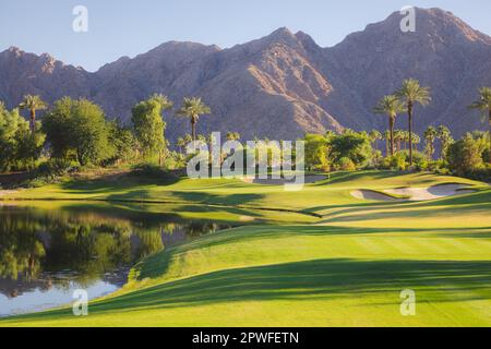 Magnifique lumière dorée sur Indian Wells Golf Resort, un parcours de golf dans le désert à Palm Springs, Californie, États-Unis avec vue sur les montagnes de San Bernadino. Banque D'Images