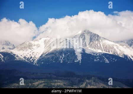 arrière-plan nature de la puissante crête de tatra au printemps à midi. sommets rocheux enneigés sous un ciel nuageux Banque D'Images