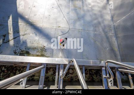 26 avril 2023, Bavière, Nuremberg: Michael, superviseur de quart et maître de piscine à Stadionbad, utilise un nettoyeur haute pression pour enlever les débris liés aux intempéries tels que les algues ou les feuilles de la piscine de plongée vide à Stadionbad pendant les travaux de nettoyage en préparation de la saison 2023 piscine extérieure. Selon les conditions météorologiques, les premières piscines extérieures devraient ouvrir début mai, d'autres le suivant au milieu du mois, selon plusieurs villes bavaroises et des exploitants de piscines municipales. Les prix d'entrée restent stables dans de nombreux endroits, mais de nombreux exploitants de piscine se plaignent de la faiblesse du personnel Banque D'Images
