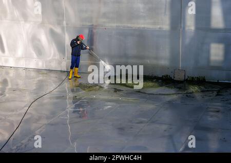 26 avril 2023, Bavière, Nuremberg: Michael, superviseur de quart et maître de piscine à Stadionbad, utilise un nettoyeur haute pression pour enlever les débris liés aux intempéries tels que les algues ou les feuilles de la piscine de plongée vide à Stadionbad pendant les travaux de nettoyage en préparation de la saison 2023 piscine extérieure. Selon les conditions météorologiques, les premières piscines extérieures devraient ouvrir début mai, d'autres le suivant au milieu du mois, selon plusieurs villes bavaroises et des exploitants de piscines municipales. Les prix d'entrée restent stables dans de nombreux endroits, mais de nombreux exploitants de piscine se plaignent de la faiblesse du personnel Banque D'Images