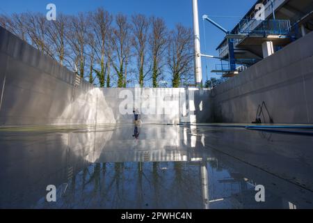 26 avril 2023, Bavière, Nuremberg: Michael, superviseur de quart et maître de piscine à Stadionbad, utilise un nettoyeur haute pression pour enlever les débris liés aux intempéries tels que les algues ou les feuilles de la piscine de plongée vide à Stadionbad pendant les travaux de nettoyage en préparation de la saison 2023 piscine extérieure. Selon les conditions météorologiques, les premières piscines extérieures devraient ouvrir début mai, d'autres le suivant au milieu du mois, selon plusieurs villes bavaroises et des exploitants de piscines municipales. Les prix d'entrée restent stables dans de nombreux endroits, mais de nombreux exploitants de piscine se plaignent de la faiblesse du personnel Banque D'Images