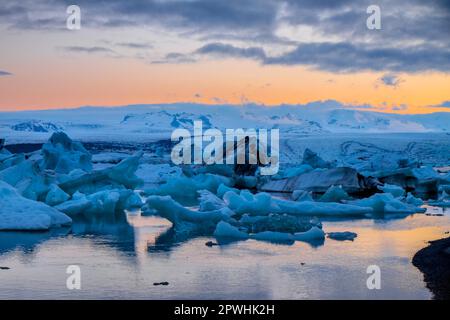 Le lagon du glacier de Jokulsarlon en Islande sous le soleil de minuit Banque D'Images