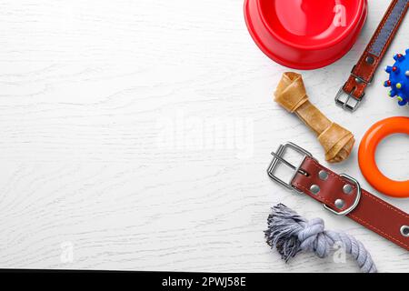 Composition de pose plate avec colliers pour chiens et différents accessoires sur table en bois blanc, espace pour le texte Banque D'Images