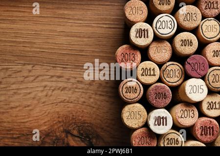 Composition de la nappe avec de nombreux bouchons à vin avec différentes dates sur table en bois. Espace pour le texte Banque D'Images