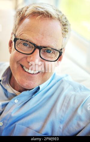 Je ne pourrais pas être plus heureux maintenant que je suis à la retraite. Portrait d'un heureux homme mature se reposant sur le canapé à la maison. Banque D'Images