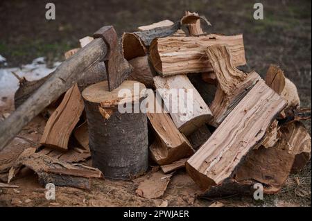 Le concept de broyage du bois pour la chaleur du feu. Encore composition de la vie avec hache et bois de chauffage dans la cour dans le style rustique Banque D'Images