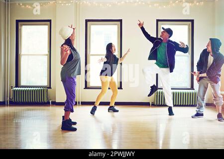 Des mouvements de danse qui sont toutes sortes d'impressionnants. un groupe de jeunes amis dansant ensemble dans un studio. Banque D'Images