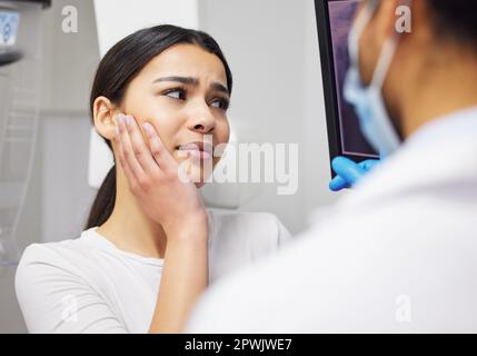 La chirurgie est la seule voie à suivre. un dentiste discutant des résultats d'une radiographie des dents d'un patient Banque D'Images