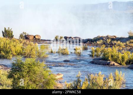 Parc national d'Augrabies, Afrique du Sud - février 28 2023 : touristes traversant un sentier inondé près de la principale cascade d'Augrabies dans la rivière Orange. Le Banque D'Images