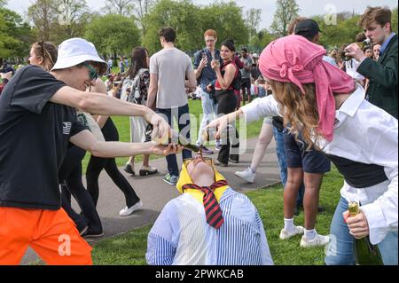 Jesus Green, Cambridge, le 30 avril 2023 des étudiants de l'Université de Cambridge, habillés en banane en pyjama, ont participé à un jeu à boire dimanche après-midi sous le soleil de la fête de la banque pour la soirée annuelle 'Caesarian Sunday'. Les étudiants de premier cycle de la prestigieuse institution bousculaient tout au long de l'après-midi en tenue de fantaisie prenant part à des jeux à boire sur Jesus Green. La tradition, également connue sous le nom de «dimanche C» attire des milliers d'étudiants juste avant qu'ils ne prennent part aux examens. La police était présente pour contrôler les universitaires. Crédit : arrêtez Press Media/Alamy Live News Banque D'Images