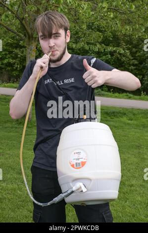 Jesus Green, Cambridge, le 30 avril 2023 Un garçon a apporté sa propre bière brassée à la maison à la fête alors que des hordes d'étudiants de l'Université de Cambridge affluaient dans un parc le dimanche après-midi dans le soleil des vacances bancaires pour la fête annuelle 'Caesarian Sunday'. Les étudiants de premier cycle de la prestigieuse institution bousculaient tout au long de l'après-midi en tenue de fantaisie prenant part à des jeux à boire sur Jesus Green. La tradition, également connue sous le nom de «dimanche C» attire des milliers d'étudiants juste avant qu'ils ne prennent part aux examens. La police était présente pour contrôler les universitaires. Crédit : arrêtez Press Media/Alamy Live News Banque D'Images