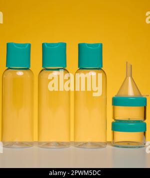 Flacons en plastique transparent pour cosmétiques liquides sur fond jaune Banque D'Images