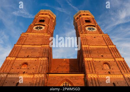 Les deux tours de la Frauenkirche dans la vieille ville de Munich en face d'une couverture nuageuse claire avec des nuages voiles et ciel bleu dans une vue extrême du fond Banque D'Images