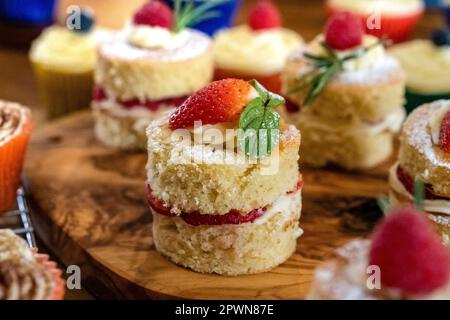 Magnifiques mini éponges Victoria c'est des framboises de fruits frais fraises remplies de crème au beurre et de fruits Banque D'Images