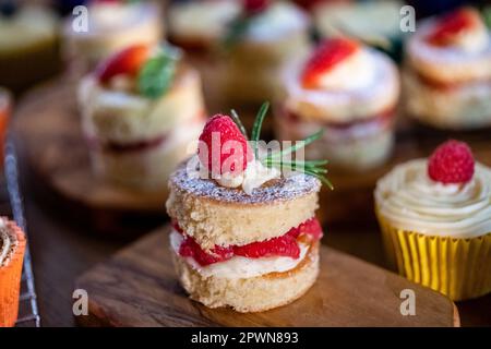 Magnifiques mini éponges Victoria c'est des framboises de fruits frais fraises remplies de crème au beurre et de fruits Banque D'Images