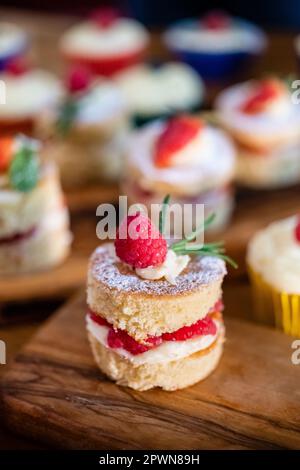 Magnifiques mini éponges Victoria c'est des framboises de fruits frais fraises remplies de crème au beurre et de fruits Banque D'Images