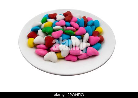 Plaque blanche avec bonbons multicolores en forme de cœur (gros plan) isolés sur un fond blanc. Vue de dessus Banque D'Images