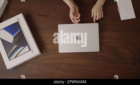 Saint-Pétersbourg, Russie - Circa décembre, 2022 : homme déballant le nouveau macbook pro 14 m1 pro puce sur la table en bois, contenu de marque Banque D'Images