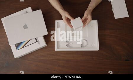 Saint-Pétersbourg, Russie - Circa décembre, 2022 : homme déballant le nouveau macbook pro 14 m1 pro puce sur la table en bois, contenu de marque Banque D'Images