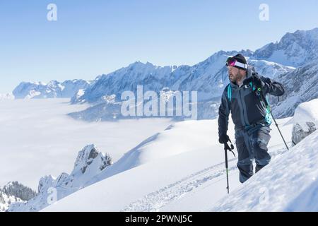 Skieur grimpant la piste de ski, Bavière, Allemagne, Europe Banque D'Images