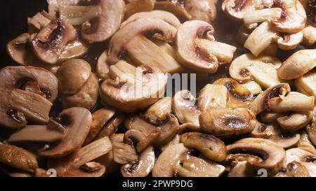 Les Champignons sont cuits dans une casserole. Prise de vue macro. Banque D'Images