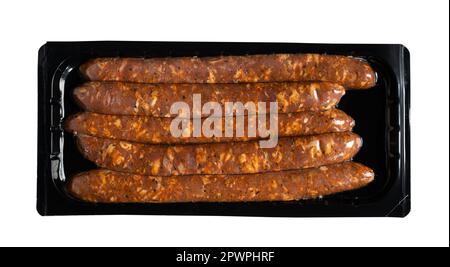 vue de dessus des saucisses fumées de salami dans un emballage noir en plastique transparent à vide isolé sur du blanc Banque D'Images