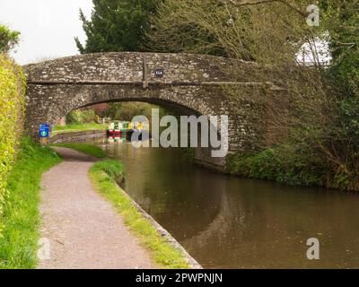 Bateau à Narrowboat passant devant un bateau amarré approchant le pont 154 sur le Monbucshire et le canal Brecon à Pencelli Powys Mid Wales UK Banque D'Images