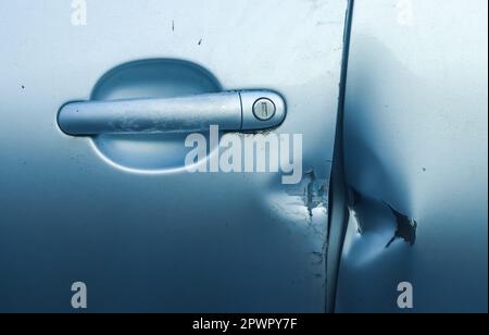 Porte de voiture avec des marques de rodage provenant d'un pied-de-biche près de la poignée Banque D'Images