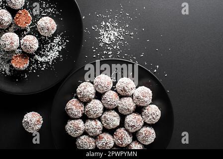 Délicieuses boules de chocolat à la noix de coco enrobées de noix de coco râpées. Boules de noix de coco douces, délicieuses et fudgy avec rhum, biscuit et chocolat. Banque D'Images