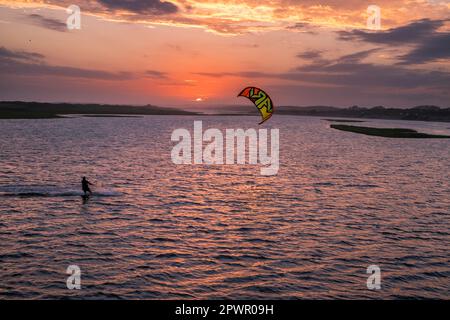 Un homme navigue son kite board au-dessus de la lagune de Garzón au coucher du soleil, Maldonado, Uruguay Banque D'Images