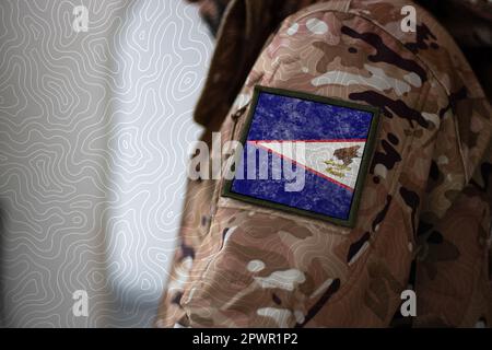 Soldat des Samoa américaines. Soldat avec drapeau Samoa américaines, drapeau des Samoa américaines sur un uniforme militaire. Vêtements de camouflage Banque D'Images