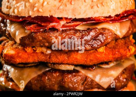 Double hamburger avec bacon grillé fromage jaune oignons tomates concombres et laitue. Résumé de la restauration rapide. Banque D'Images